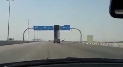 Dump truck smashes through overhanging road sign (video)