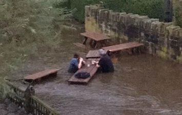 Waist-high floods could not stop this pair finishing their beergarden pints