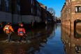 Syrian refugees help to clear up streets and homes ravaged by floods