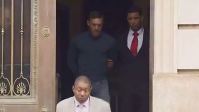 Handcuffed Conor McGregor is led out of police station