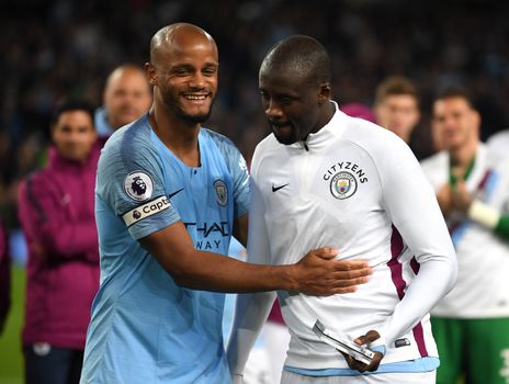 MANCHESTER, ENGLAND - MAY 09: Vincent Kompany of Manchester City embraces Yaya Toure of Manchester City as he is presented with a shirt in a frame during the Premier League match between Manchester City and Brighton and Hove Albion at Etihad Stadium on May 9, 2018 in Manchester, England. (Photo by Gareth Copley/Getty Images)