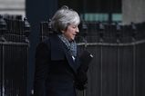 Armed police officer delivers two boxes of Krispy Kreme doughnuts to Downing Street