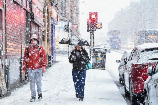 GLASGOW, SCOTLAND - JANUARY 22: Members of the public make their way through a snow shower in the West End on January 22, 2019 in Glasgow, Scotland. The Met Office has issued a yellow weather warning for snow and ice with large parts of the country likely to be affected by the drop in temperature. (Photo by Jeff J Mitchell/Getty Images)