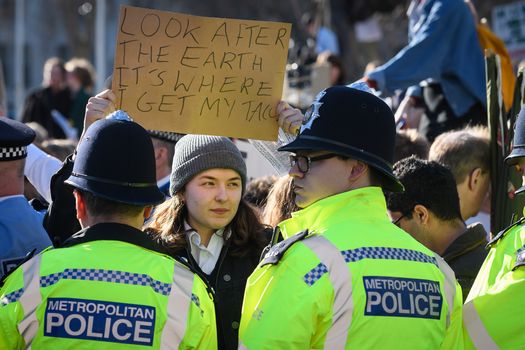 LONDON, ENGLAND - FEBRUARY 15: A student holds up her placard as members of the police attempt to clear the roads around Parliament Square during a climate protest on February 15, 2019 in London, United Kingdom. Thousands of UK pupils from schools, colleges and universities will walk out today for a nationwide climate change strike. Students in 60 cities from the West Country to Scotland are protesting, urging the government to declare a climate emergency and take action over the problem. They are keen that the national curriculum is reformed and the environmental crisis is communicated to the public. Similar strikes have taken place in Australia and in European countries such as Belgium and Sweden. (Photo by Leon Neal/Getty Images)