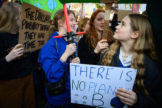 LONDON, UNITED KINGDOM - FEBRUARY 15: A student uses a Star Wars lightsaber toy to hold her placard during a climate protest in Parliament Square on February 15, 2019 in London, United Kingdom. Thousands of UK pupils from schools, colleges and universities will walk out today for a nationwide climate change strike. Students in 60 cities from the West Country to Scotland are protesting, urging the government to declare a climate emergency and take action over the problem. They are keen that the national curriculum is reformed and the environmental crisis is communicated to the public. Similar strikes have taken place in Australia and in European countries such as Belgium and Sweden. (Photo by Leon Neal/Getty Images)