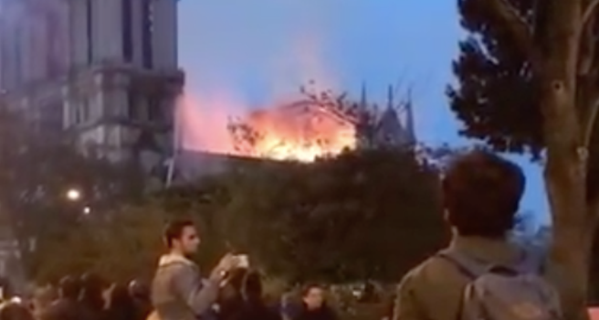 Notre Dame burns as Parisians sing and watch in horror.