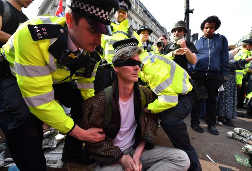 Metropolitan Police officers arrest an Extinction Rebellion protester