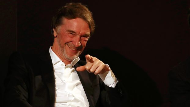 Sir Jim Ratcliffe smiles and points at a camera