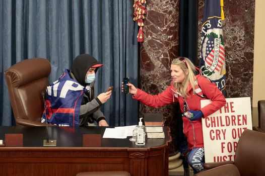 Trump supporters check their smart phones from the floor of COngress, the preisdent has been banned from social media