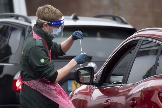 Healthcare worker with a swab at a drive in Covid-19 test centre