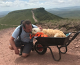 Man takes dying dog for one final walk up favourite mountain in wheelbarrow