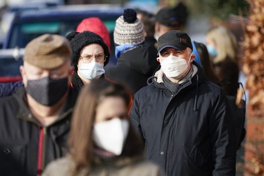 People walking in a crowd with face coverings on to prevent the spread of Covid