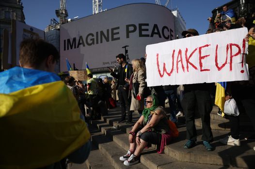 LONDON, ENGLAND - MARCH 26: Protestors hold placards at Piccadilly Circus during the London stands with Ukraine march and rally on March 26, 2022 in London, England. Russia invaded neighboring Ukraine on 24th February 2022. Its actions have met with worldwide condemnation with rallies, protests and peace marches taking place in cities across the globe. (Photo by Hollie Adams/Getty Images)